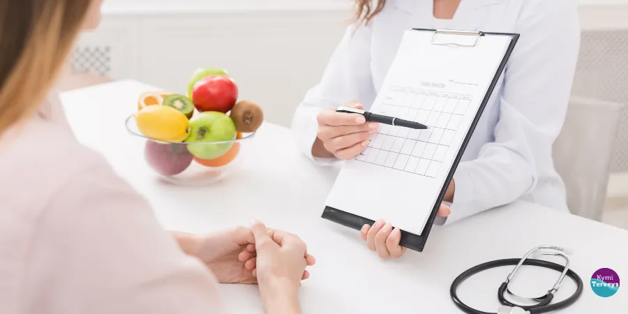 ravitsemus-ohjaus-artikkelikuvana Ravitsemusasiantuntija keskustelee asiakkaan kanssa arjen syömisestä ja ravitsemuksesta.